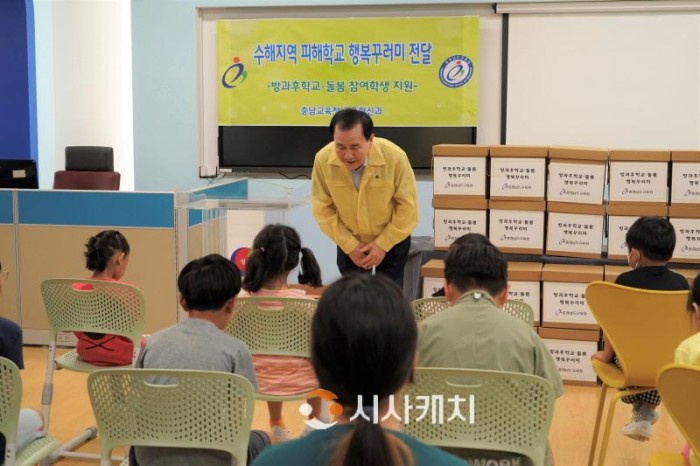 [크기변환](사진1) 김지철 교육감은 24일 청양 청남초등학교에 방문하여 수해피해 지역 방과후·돌봄 참여학생들에게 행복꾸러미를 전달하며 인사하고 있다.jpg